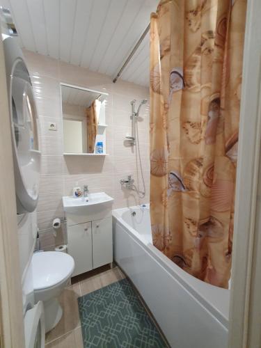 Un baño con bañera, inodoro y lavabo. en Dainai 1-Bedroom apartament., en Šiauliai