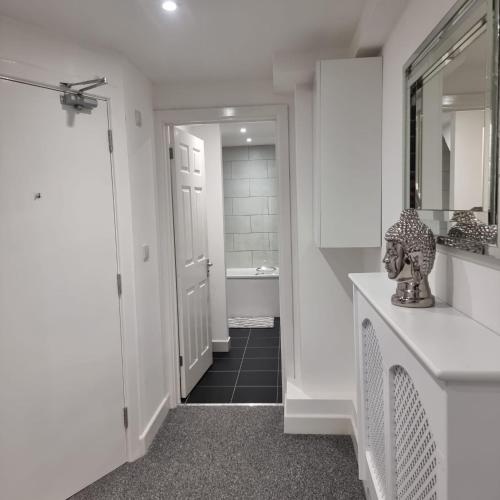 a hallway with a bathroom with a sink and a mirror at Classic 2 bed apartment in oldkent road in London