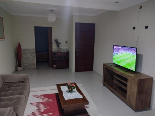 a living room with a flat screen tv on a table at Hospedagem da Val in Angra dos Reis