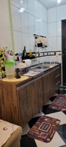 uma cozinha com um lavatório e um balcão com tapetes em Hostel Beto Carrero em Itajaí