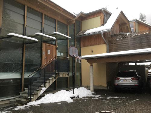 a snow covered building with a car parked outside at Ferienappartment in St Oswald - Bad Kleinkirchheim Nähe der Skipiste in Obertschern