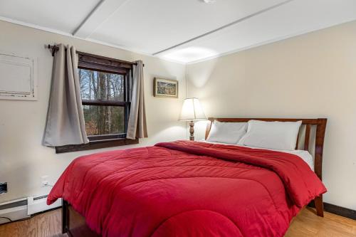 a bedroom with a large bed with a red blanket at Woodward Grove in Plymouth