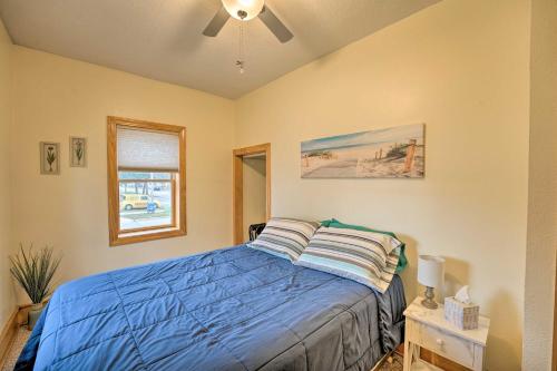 a bedroom with a blue bed with a ceiling fan at All-Season Grand Haven Getaway with Deck! in Grand Haven