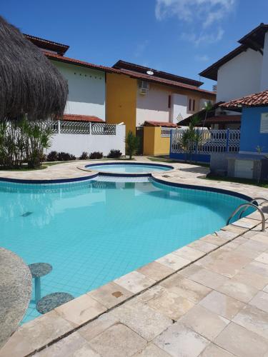 塔曼達雷的住宿－Casa12_Carneiros，一座房子前面的蓝色海水游泳池
