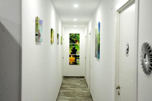a hallway with white walls and art on the walls at River Dreams in Deltebre