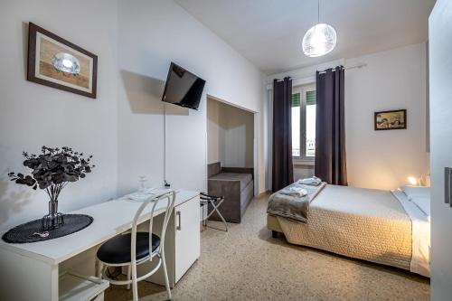 a bedroom with a bed and a desk and a television at Maison Bianca B&B in Florence