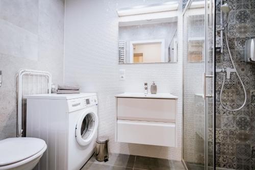 biała łazienka z pralką i prysznicem w obiekcie Ottimo Apartamenty Floriana w Bydgoszczy