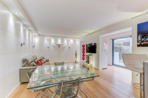 uma sala de estar com uma mesa de vidro e um sofá em Appartement Standing à Toulouse en centre ville em Toulouse