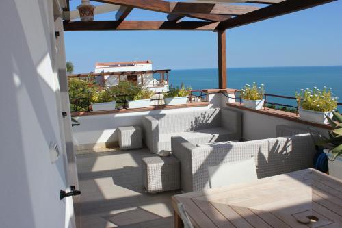 a balcony with white chairs and a view of the ocean at Holiday Lodge al Porto in Mattinata