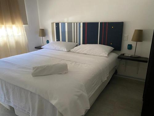 um quarto com uma grande cama branca e 2 almofadas em FRIDA'S Home Sol A em Puerto Morelos