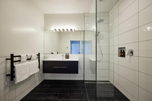 a bathroom with a sink and a glass shower at Koura Bay Golf Resort in Kaikoura