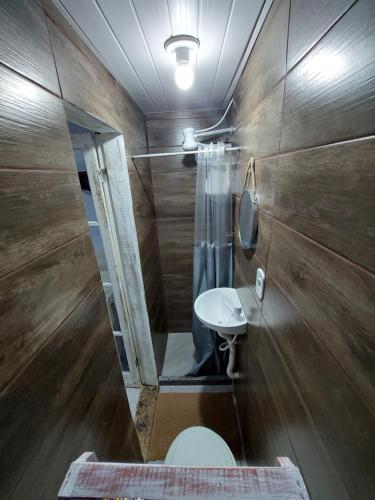 a bathroom with a toilet and a sink and a mirror at Casa da Arara in Saquarema
