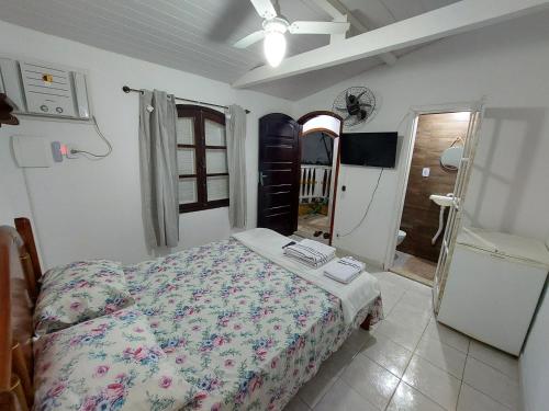 a bedroom with a bed and a tv in it at Casa da Arara in Saquarema