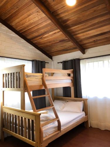 two bunk beds in a room with a wooden ceiling at High-end Holiday Cabin - Tungurahua Hot Springs in Baños