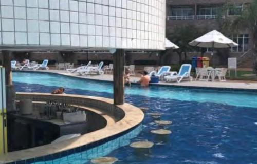 a large swimming pool with rocks in the water at Gran Lençóis Flat Apartamento in Barreirinhas
