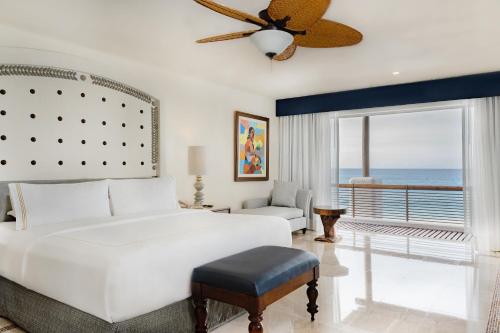 a bedroom with a white bed and a view of the ocean at Marquis Los Cabos, an All - Inclusive, Adults - Only & No Timeshare Resort in San José del Cabo