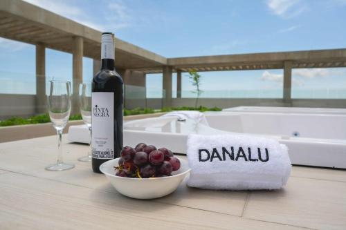 a bottle of wine and a bowl of grapes on a table at Suite de lujo Distrito 90 in Barranquilla