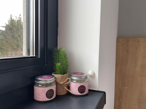 two jars sitting on a shelf next to a window at Apartman Nostalgija - Titova Vila in Palisad