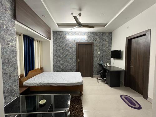 a bedroom with a bed and a desk in it at GREEN HOME STAY in Lucknow