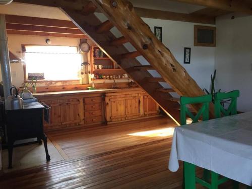 a kitchen with a wooden staircase in a room at La Joaquina, Casa de montaña. in El Chalten