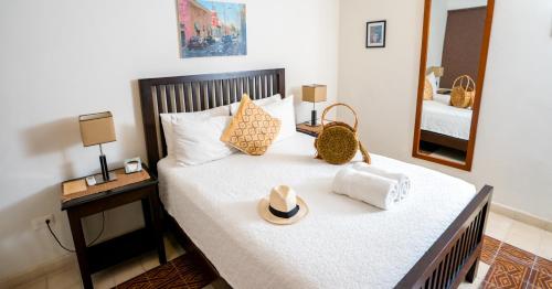 a bedroom with a bed with a hat and a mirror at Boutique by The Museo in Mérida