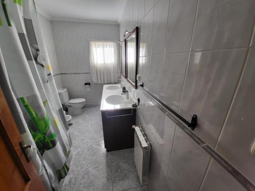 uma casa de banho com um lavatório e um WC em Fogar Rivoira Sacrata em Castro Caldelas