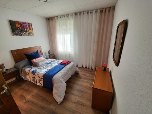a bedroom with a bed and a table in it at Fogar Rivoira Sacrata in Castro Caldelas
