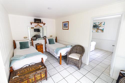 a bedroom with two beds and a chair in it at Chillagoe Cabins and Tours in Chillagoe
