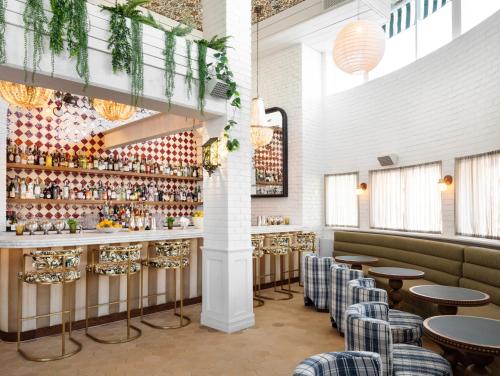 un restaurante con mesas y sillas y un bar en Palihouse West Hollywood en Los Ángeles