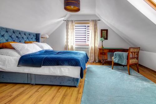sypialnia z niebieskim łóżkiem i biurkiem w obiekcie Rentimi - Willa Bella Kościelna 28 w Muszynie