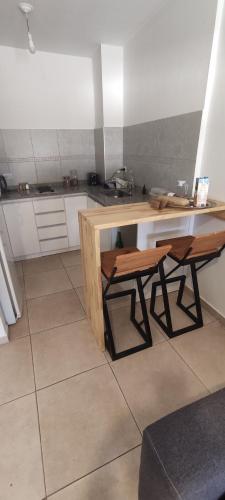 a kitchen with a wooden desk and a table at Bauhaus departamento centro in Córdoba