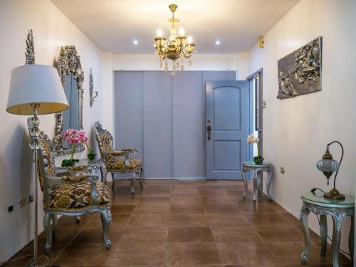 un pasillo con una puerta azul, sillas y una mesa en The Royalty Inn ApartmentHotel #1 en Guayaquil
