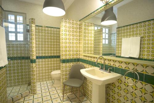 La salle de bains est pourvue d'un lavabo, de toilettes et d'un miroir. dans l'établissement AmazINN Places Rooftop and Jacuzzi IV, à Panama City