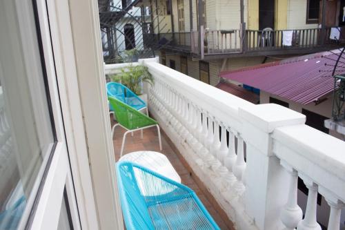 balkon z 2 niebieskimi krzesłami w budynku w obiekcie AmazINN Places Rooftop and Jacuzzi V w Panamie