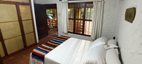 a white bed in a room with two windows at Villa Margarita in Puerto Colombia