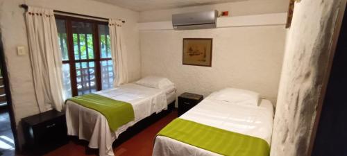 a room with two beds and a window at Villa Margarita in Puerto Colombia