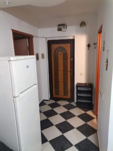 una cucina con frigorifero e pavimento a scacchi bianchi e neri di Studio Bucuresti a Bucarest