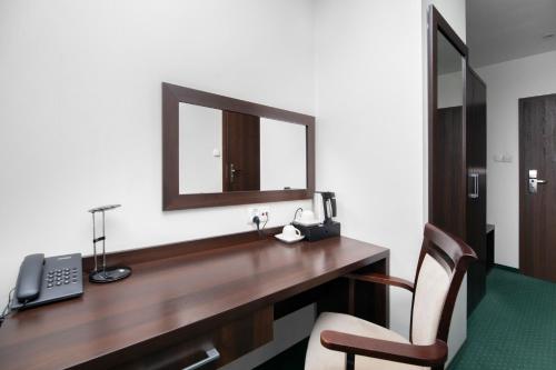 a desk with a telephone and a mirror at Hotel Maraton in Bydgoszcz