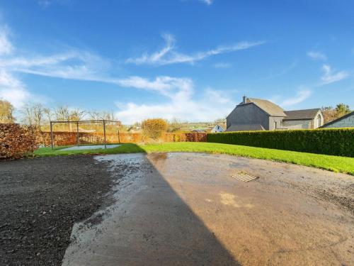 a puddle of water on a road with a house at Holiday home in Léglise with garden in Léglise
