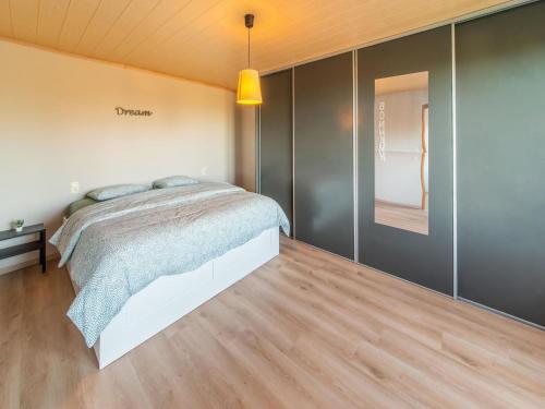 a bedroom with a bed and a wooden floor at Holiday home in Léglise with garden in Léglise