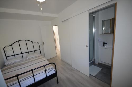 biała sypialnia z łóżkiem i łazienką w obiekcie Superbe appartement Montpellier 8 personnes 2 chambres 2 salles de bain Wifi Netflix et parking gratuit w Montpellier
