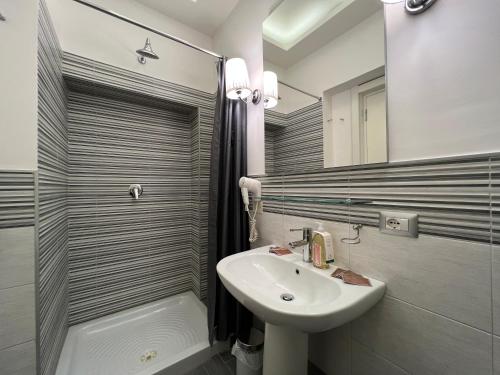 a white bathroom with a sink and a mirror at La tua casa nel centro di Roma in Rome