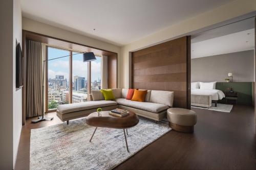 a living room with a couch and a bed at Humble Boutique Hotel in Taipei