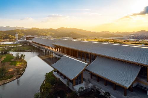 una vista aérea de un edificio con agua y montañas en 宁波东钱湖望岚酒店, en Ningbo
