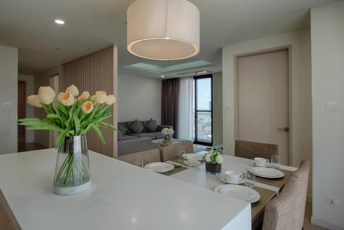 a living room with a table with a vase of flowers at GRANFERTE Phnom Penh Hotel in Phnom Penh