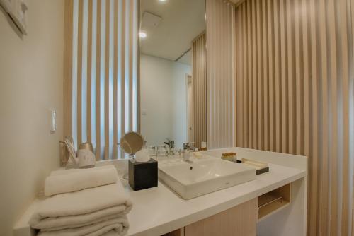 y baño con lavabo blanco y espejo. en GRANFERTE Phnom Penh Hotel, en Phnom Penh