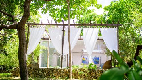 a white curtain in front of a house at The Dream Beach Resort in Taytay