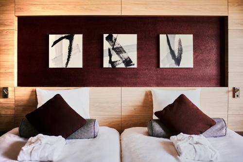 a bedroom with two beds and pictures on the wall at Asakusa View Hotel in Tokyo