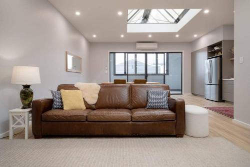 a living room with a brown couch and a window at The Ranch In The Heart Of Launceston w/ Free Wifi in Launceston