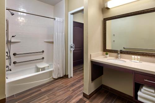 La salle de bains est pourvue d'un lavabo, d'une baignoire et d'une douche. dans l'établissement Staybridge Suites Anaheim At The Park, an IHG Hotel, à Anaheim